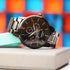 Montre moonphase Apollo noire avec gravure moderne et chronographes, mouvement japonais, boîtier acier inoxydable, présentation élégante.